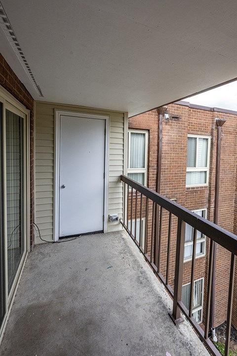 an empty porch with a door to a brick building
